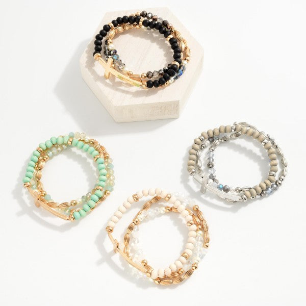 Set Of Three Beaded Stretch Bracelets Featuring Metal Tones, Wood Beads, East West Cross