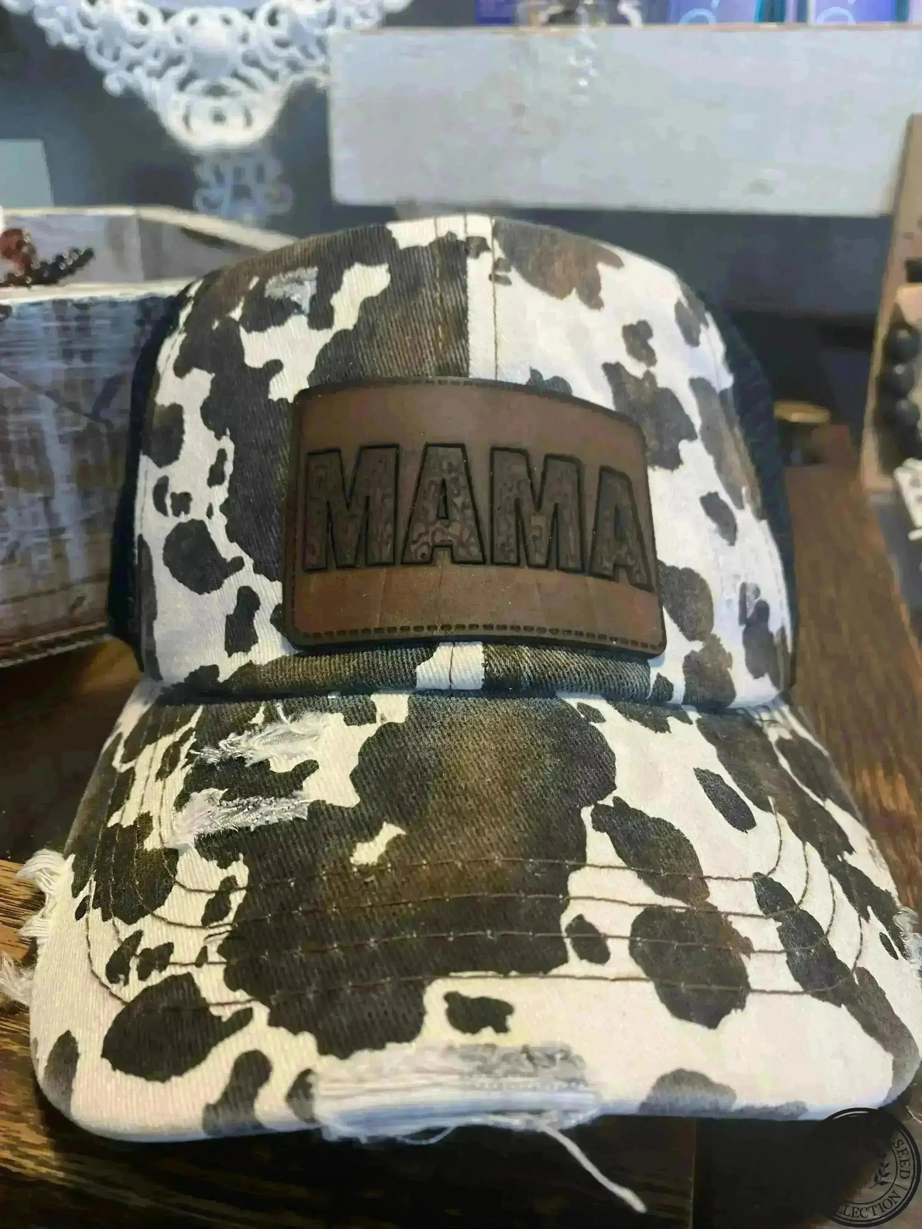 C.C Distressed Cow Print Criss Cross Pony Cap with Mesh Back With Cheetah “Mama” Leather Patch Judson
