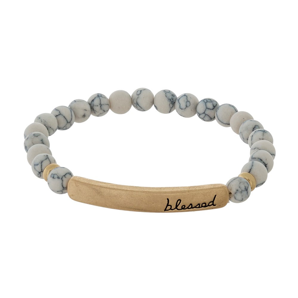 Beaded stretch bracelet with a bar focal, stamped with "blessed." Howlite