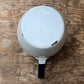 The bottom view of a white ceramic mug with a dark blue handle, resting on a rustic wooden surface.