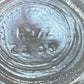 Close-up of the bottom of a clear glass jar, showing embossed circular manufacturing markings and the numbers 2336.