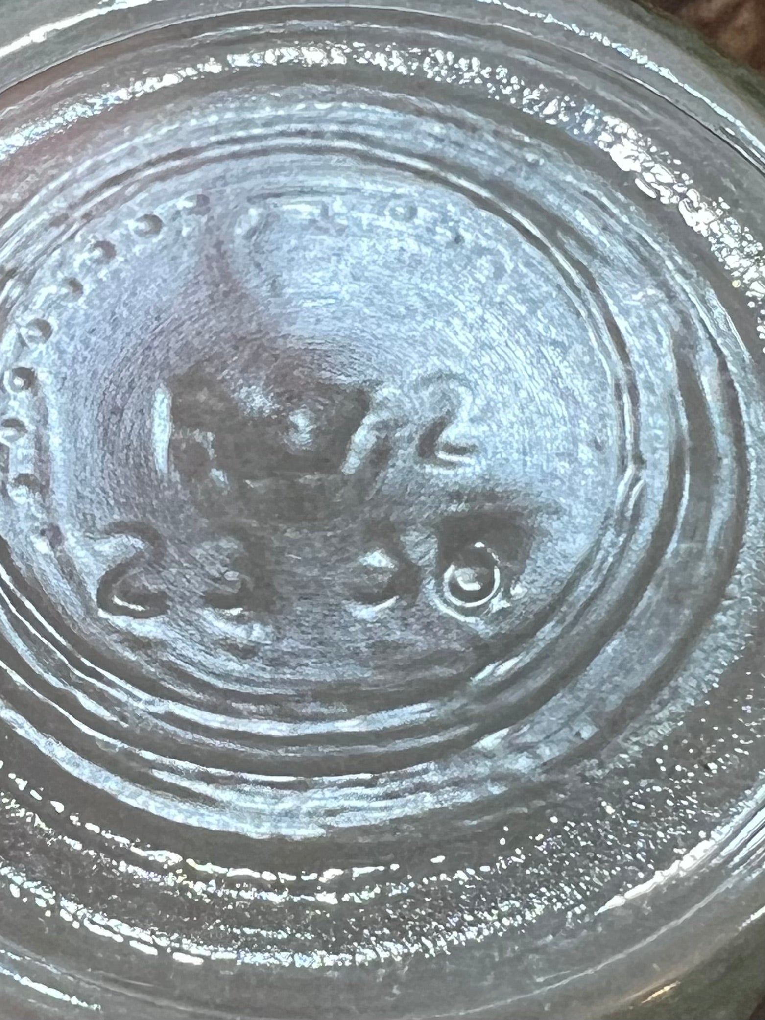 Close-up of the bottom of a clear glass jar, showing embossed circular manufacturing markings and the numbers 2336.