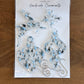 A package of Seed Valley Handmade Ornaments featuring four clear acrylic holiday ornaments with blue and black glitter patterns, displayed on a wooden table.