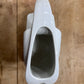 A glossy white ceramic pitcher viewed from directly above, resting on a rustic wooden surface.