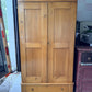 Antique pine two-piece wardrobe armoire, front view with two paneled doors and drawer base