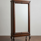 A tall, dark brown wooden cabinet with an integrated rectangular mirror, featuring ornate cabriole-style legs and a small brass handle, set against a neutral studio background.