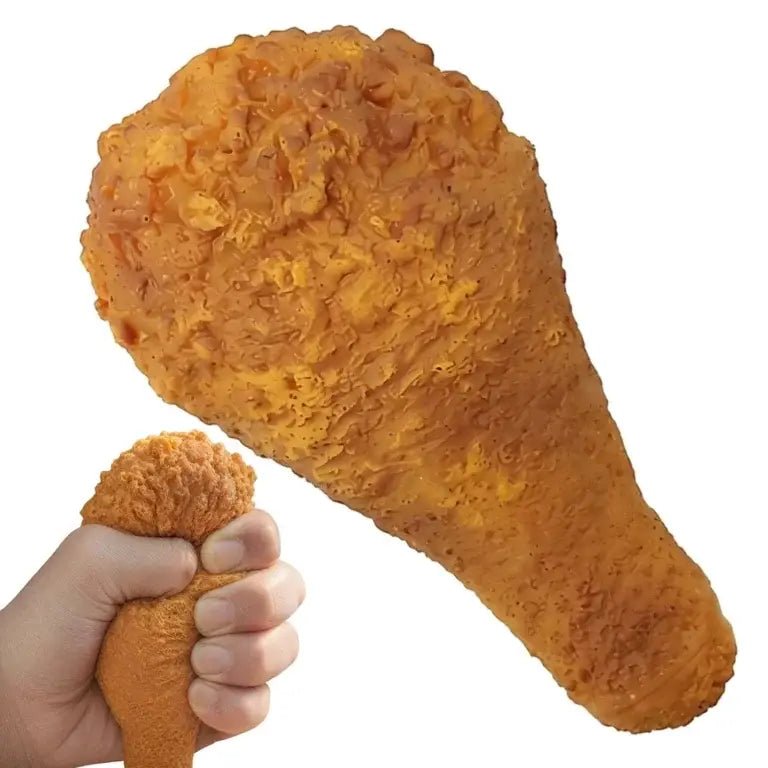 A novelty chicken leg-shaped squishy toy being squeezed by a hand, shown against a plain white background.