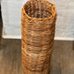 Vintage honey-brown woven wicker basket, 25 inches tall and 8 inches across