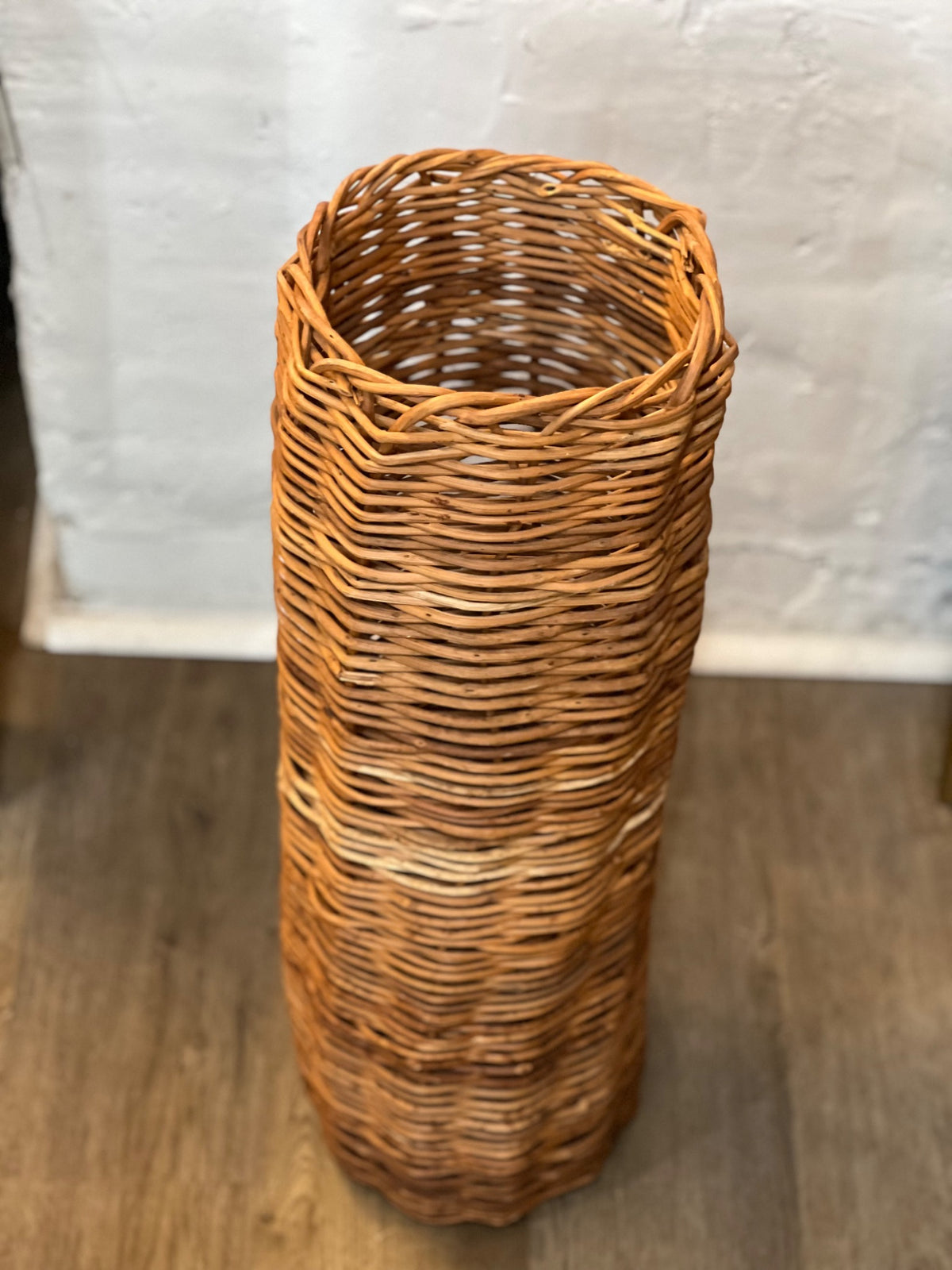Vintage honey-brown woven wicker basket, 25 inches tall and 8 inches across