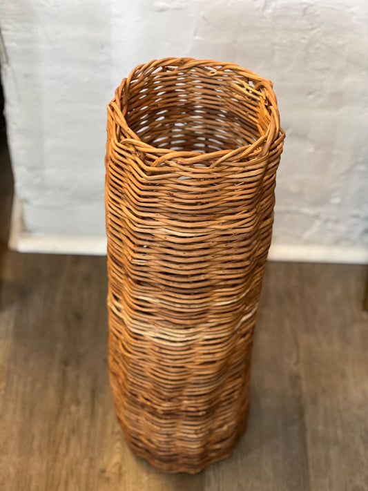 Vintage honey-brown woven wicker basket, 25 inches tall and 8 inches across